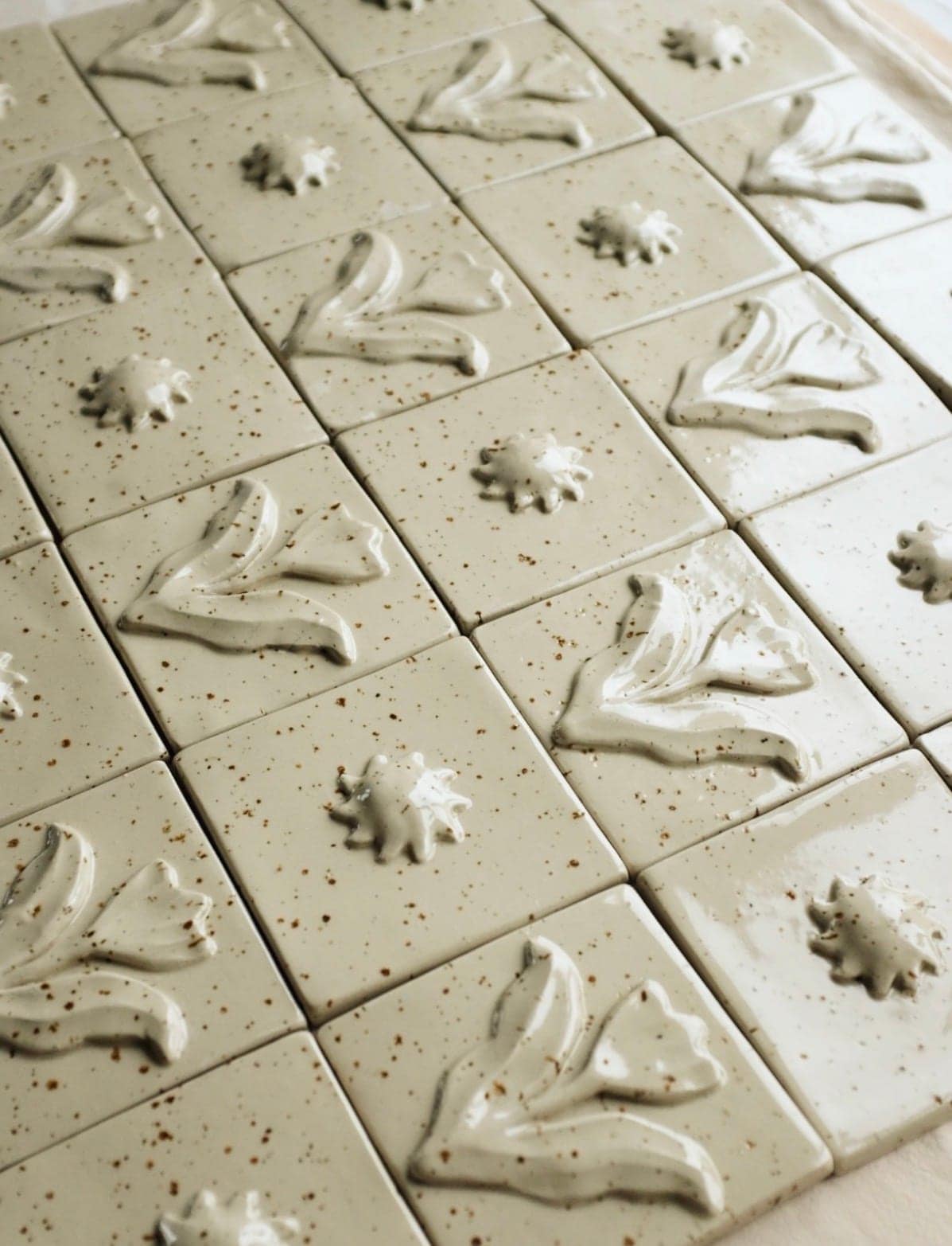 Rows of unfired relief tiles drying in the studio