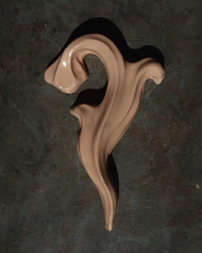 Sculptural wall piece in glossy pink glaze mounted on green marble